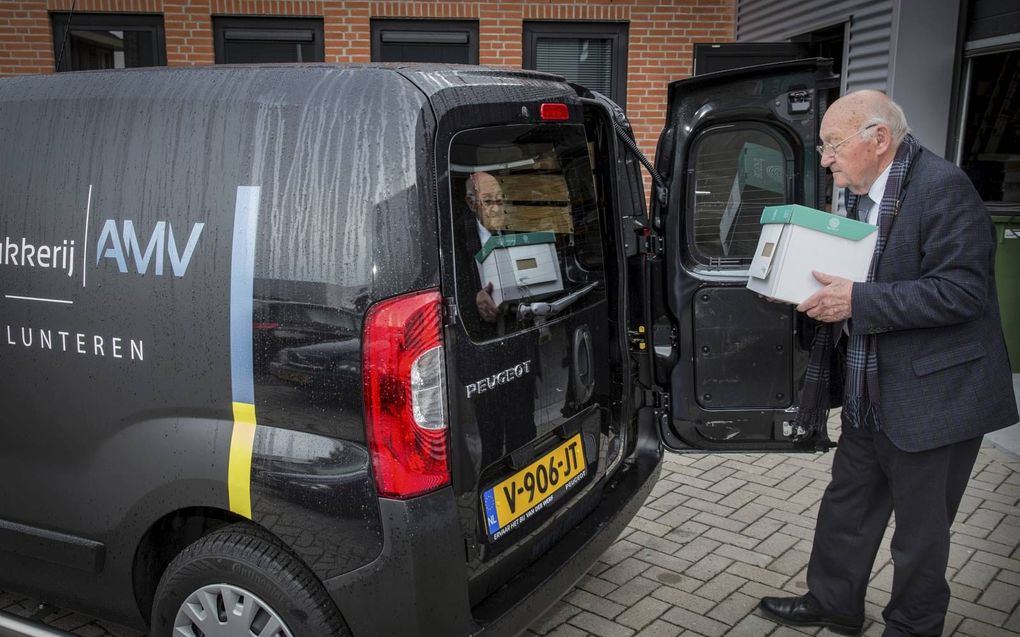 Koerier Toon Vroegop (92) laadt bij drukkerij AMV in Lunteren zijn auto in voor een volgende bezorging.  beeld RD, Henk Visscher