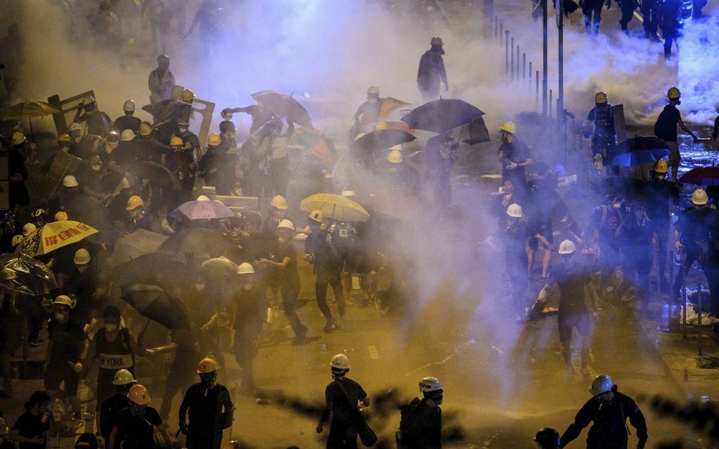 Chaotische taferelen in de straten van Hongkong, waar op 2 juli betogers door de oproerpolitie bij het parlementsgebouw worden verdreven, nadat die eerder het gebouw waren binnengedrongen. beeld AFP, Anthony Wallace