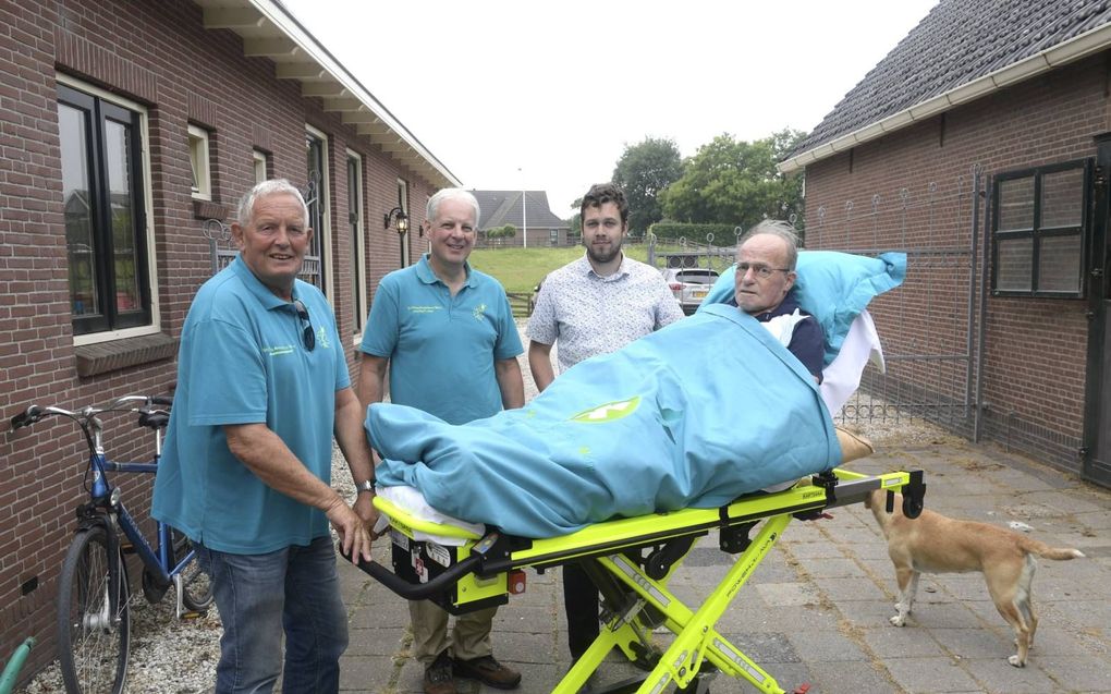 Meneer Angenent is terminaal ziek en kan zijn bed niet uit. Leo Nootenboom (links) en medevrijwilliger Peter Scholten brengen hem per brancard naar de boerderij waar de oud-agrariër 65 jaar woonde.  beeld Paul Dijkstra