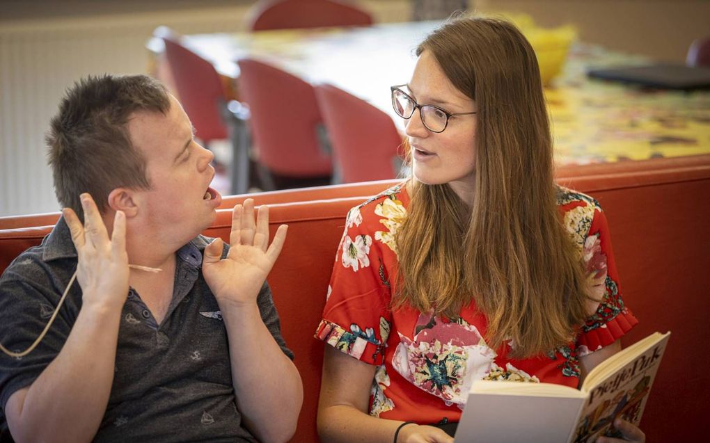 De deelnemers van IZ-groep De Dolfijn genieten van de avonturen van Pietje Puk. Redacteur Henrieke Koster leest voor uit het populaire boek. beeld RD, Henk Visscher