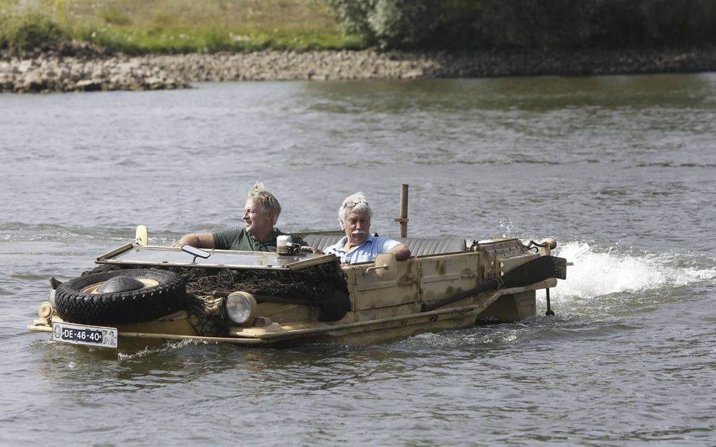 Directeur Eef Peeters (blauw shirt) van het Arnhems Oorlogsmuseum 40-45 demonstreert zijn zojuist aangeschafte Duitse Schwimmwagen op de Rijn bij Arnhem. Hij kocht het voertuig van een particulier die een volkswagen ombouwde tot amfibievoertuig. beeld Vid