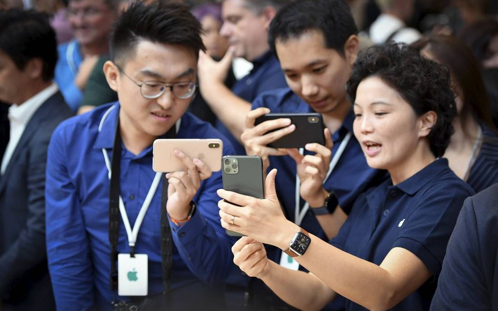 Bezoekers experimenteren met de nieuwe iPhone 11 tijdens de presentatie op het hoofdkantoor van Apple in Cupertino, Californië.  Beeld AFP Josh Edelson