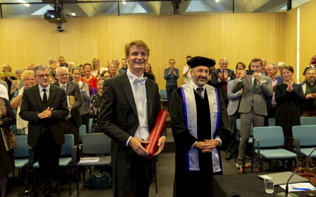 Cees Zweistra ontvangt de bul uit handen van zijn promotor, Ciano Aydin. Links achter hem zijn vader, ds. H. Zweistra, en zijn schoonvader, prof. dr. G. Immink. beeld Cees Zweistra