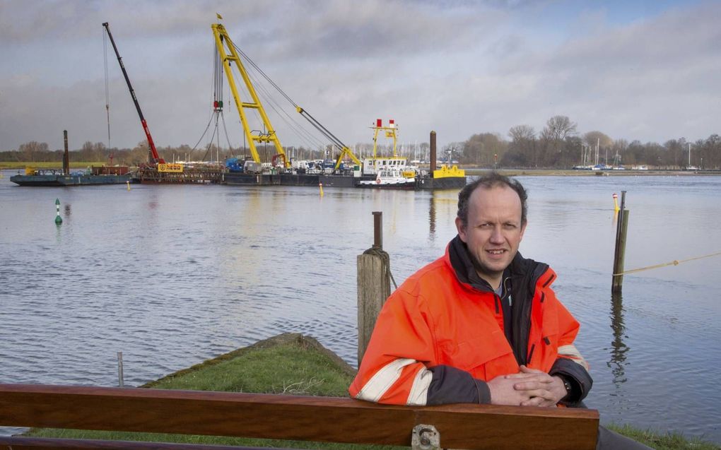 Maritiem archeoloog Wouter Waldus in 2016 met op de achtergrond de voorbereidingen voor het bergen van de kogge. beeld Freddy Schinkel