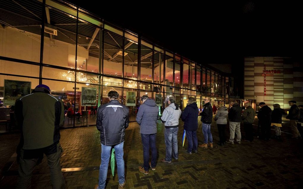 Christenen donderdagavond in gebed bij het Barneveldse theater waar het paranormale medium Derek Ogilvie optrad. beeld Jaco Klamer