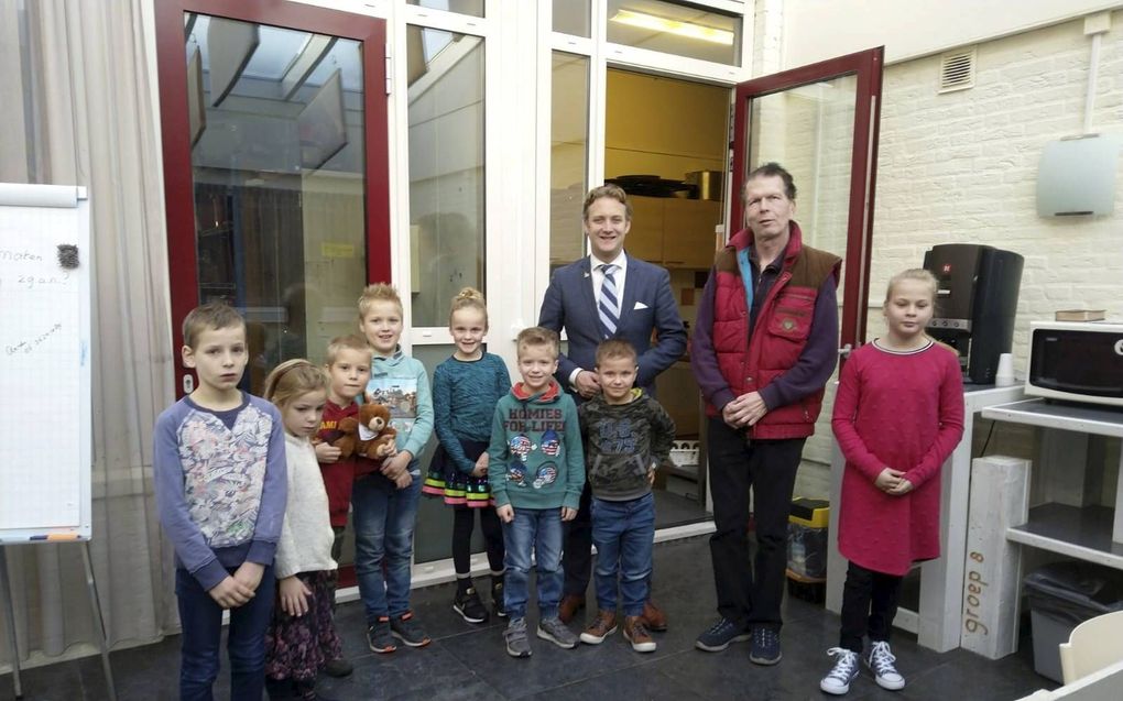 De kinderen met burgemeester Pieter Verhoeve en chauffeur Hans Bijl (in rode bodywarmer). beeld ds N.H. Beversluisschool