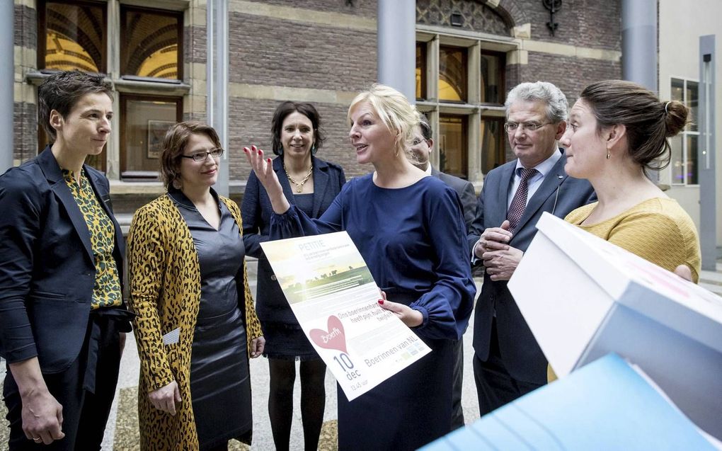 Een groep ongeruste boerinnen bood dinsdag een petitie aan in de Tweede Kamer over de gezinssituatie op en toekomstperspectief voor agrarische bedrijven. beeld ANP, Koen van Weel