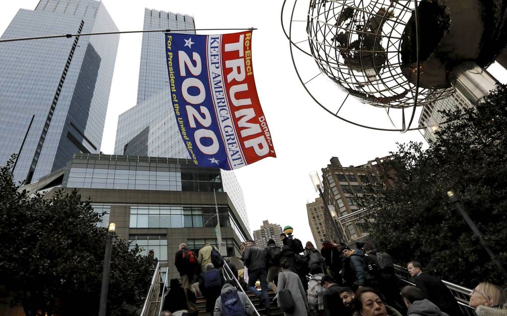 „Het aanspannen van een impeachmentprocedure door het Huis heeft het Amerikaanse Congres enorme schade heeft toegebracht.” Foto: tijdens een anti-Trumpbijeenkomst toont een Trumpaanhanger met een vlag zijn sympathie voor de president. beeld EPA, Peter Fol