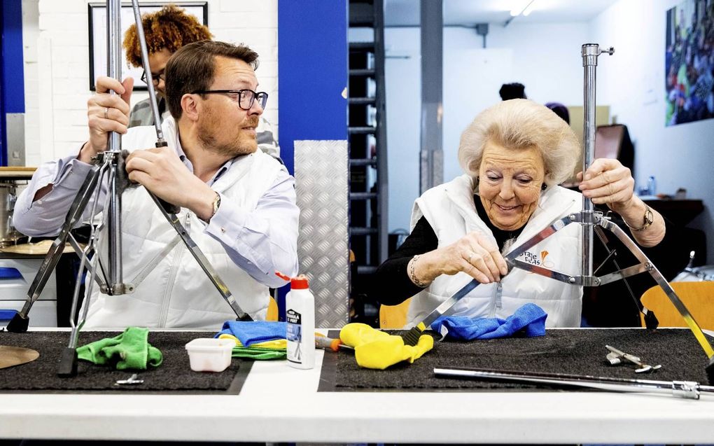 Op 13 en 14 maart houdt het Oranjefonds weer de vrijwilligersactie NLdoet. Foto: prin-ses Beatrix en prins Constantijn hielpen vorig jaar mee bij de Stichting Instrumenten-depot Leerorkest in Huizen. beeld  ANP, Patrick van Katwijk