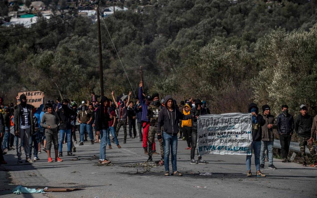 Vluchtelingen demonstreerden maandag bij Moria, na botsingen met de oproerpolitie. Hulpverleners konden het kamp niet in.   beeld AFP, Angelos Tzortzinis