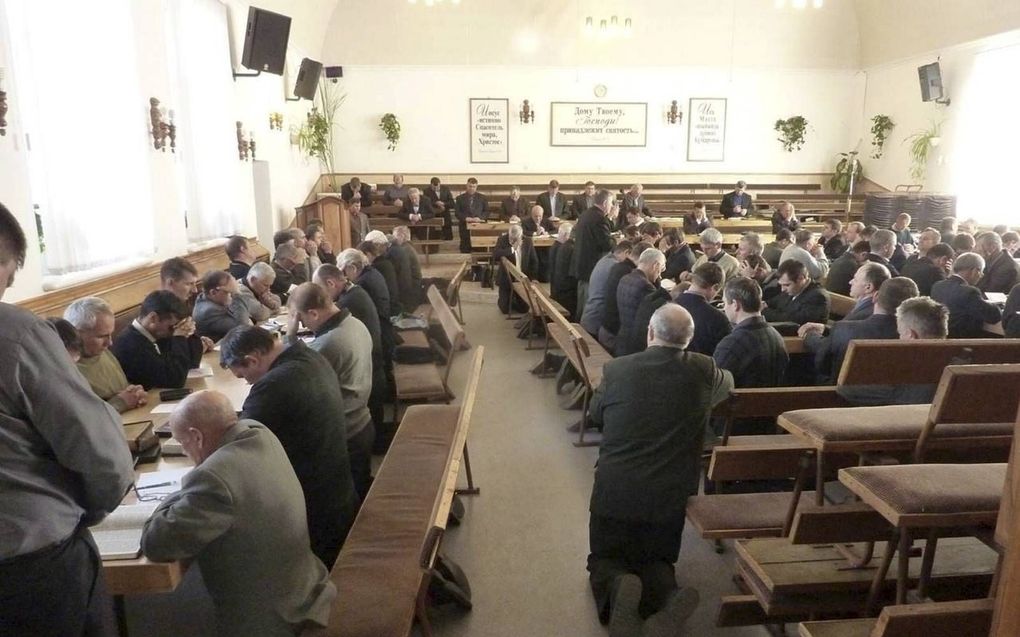 Knielende christen op een bijeenkomst in Centraal-Azië. beeld Friedensstimme