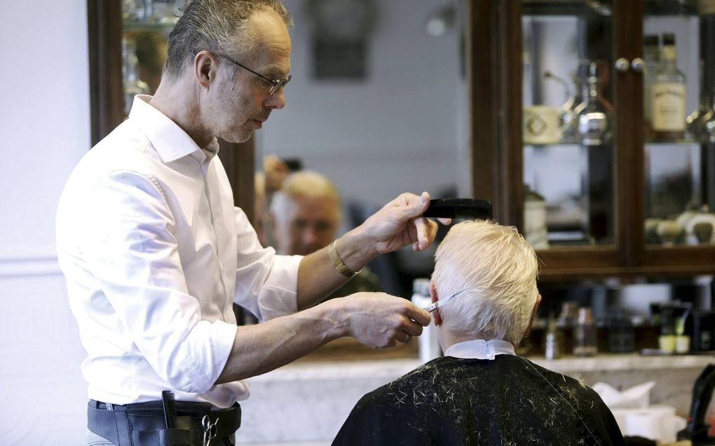 Kapper Piet van der Vliet uit Bennekom beleeft vanwege de coronacrisis drukke tijden. „Mijn agenda is overvol en de telefoon staat roodgloeiend.”  beeld VidiPhoto