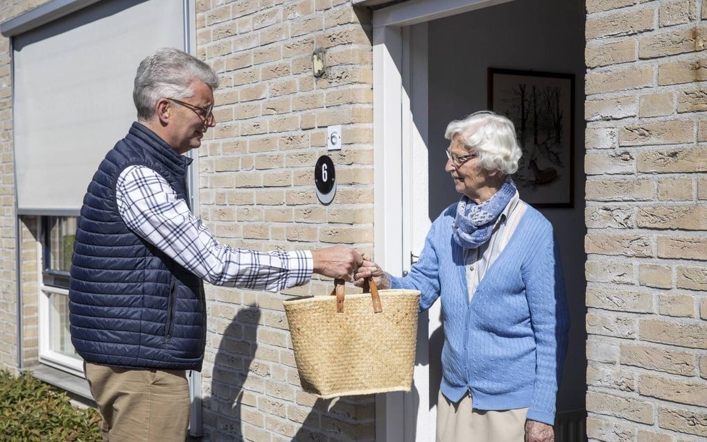 Diaken André Vink van de christelijke gereformeerde kerk in Middelharnis doet wekelijks boodschappen voor een oudere uit zijn gemeente. Hier staat hij op de foto met zijn moeder.  beeld RD, Anton Dommerholt