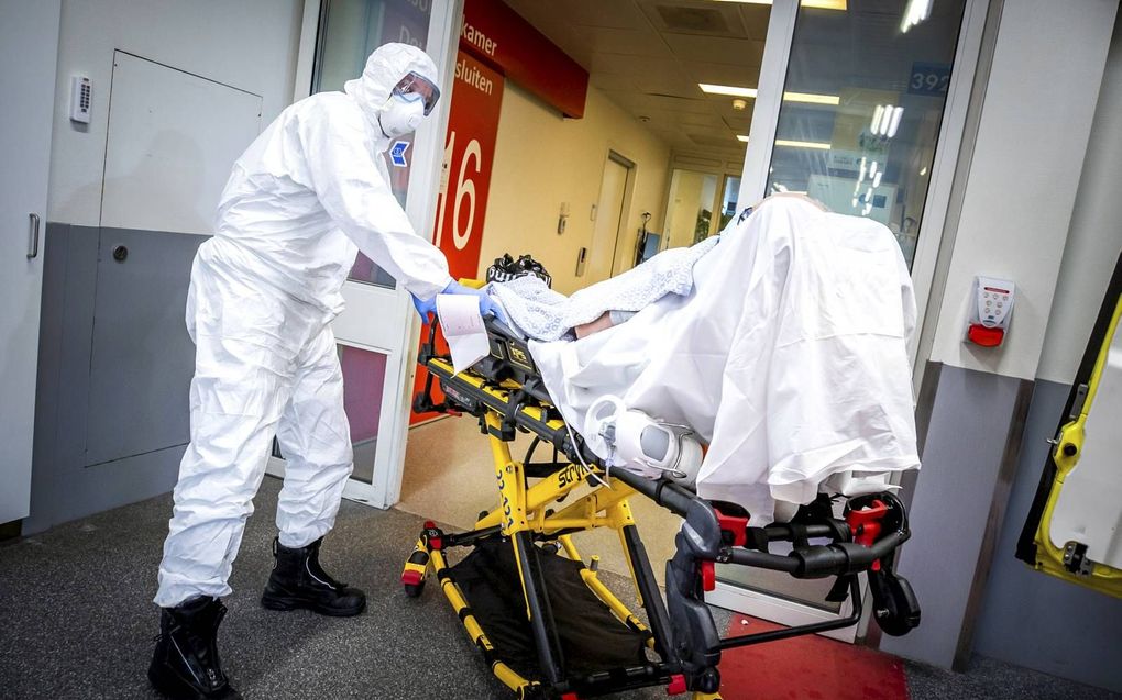 Alle hens aan dek was het afgelopen weken voor zorgpersoneel in ziekenhuizen en zorgcentra. Zeker in Brabant, de grootste brandhaard tijdens de coronacrisis, raakten ziekenhuizen overbelast. Foto: een ambulancemedewerker brengt een coronapatiënt binnen bi