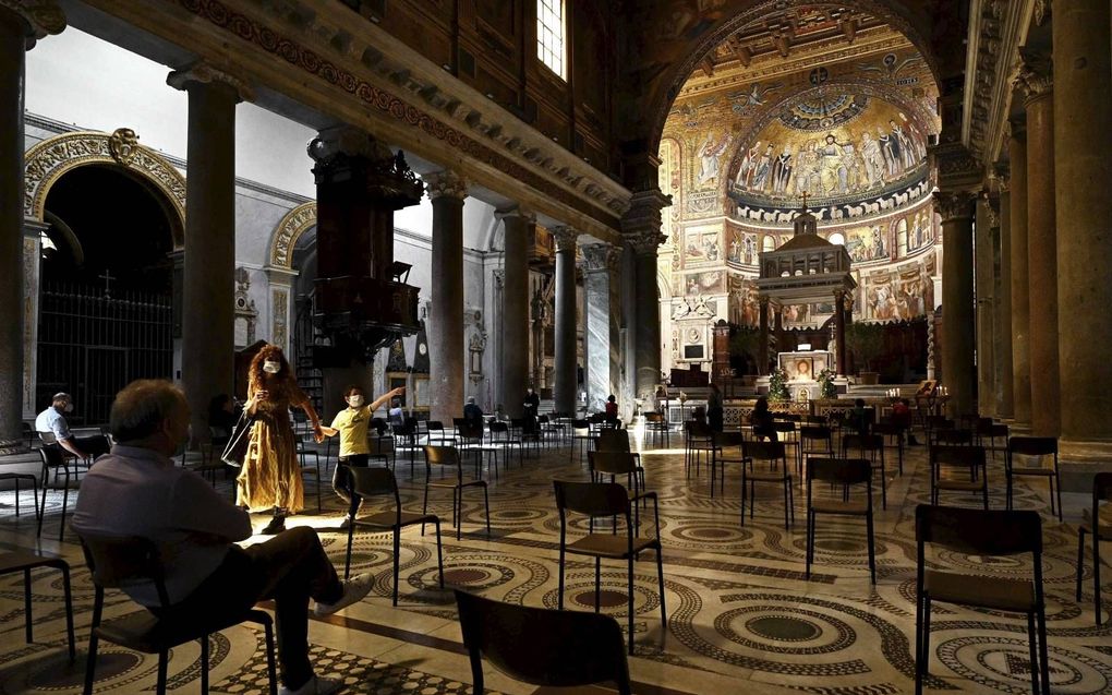 Rooms-katholieken bidden in de oudste Mariakerk van Rome, terwijl ze de afstandregels in acht nemen. beeld AFP, Vincenzo Pinto