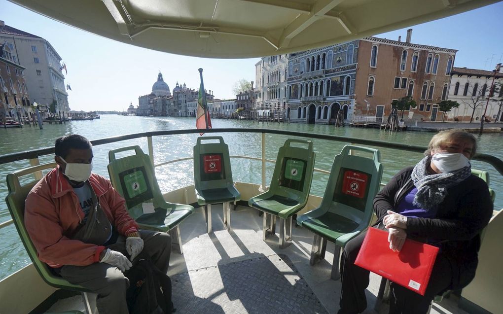 Inwoners van Venetië varen over het Canal Grande in de beroemde Italiaanse stad. Evenals veel andere Europese landen wacht de Italiaanse toeristenbranche met smart op het opheffen van beperkende maatregelen, zodat zij weer toeristen kan ontvangen.  beeld 