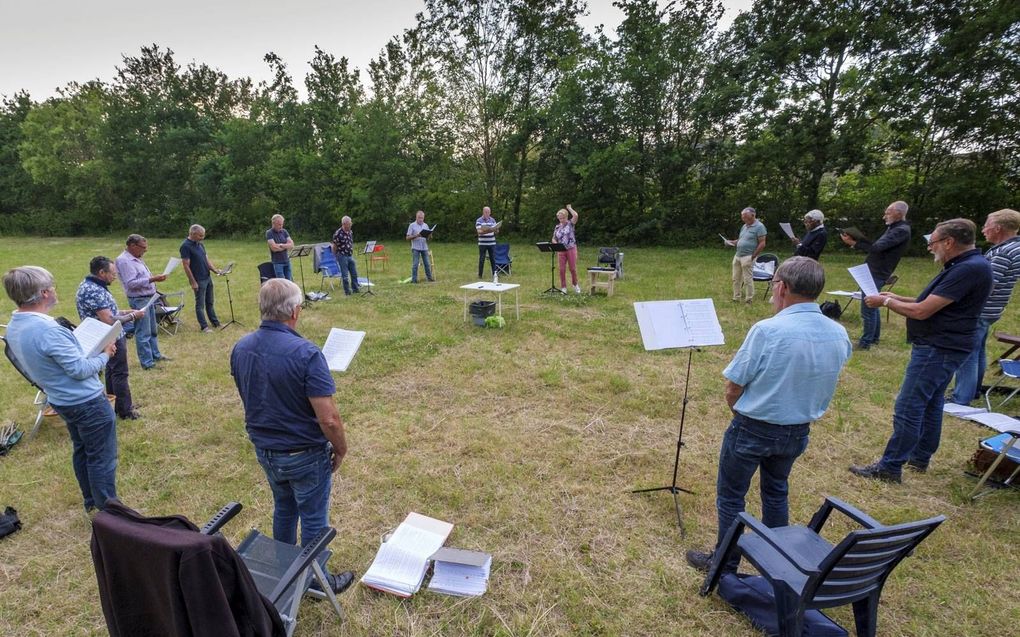 Mannenensemble Lezzom uit het Zeeuwse Gapinge repeteert sinds 1 juni –als het weer het toelaat– wekelijks in de buitenlucht. Normaal oefenen de zestien mannen in een dorpshuis, maar binnen zingen vinden ze nu te gevaarlijk omdat de meeste koorleden tot ee