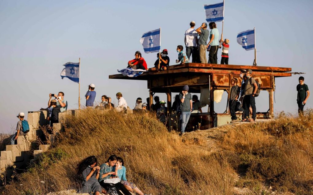 Israëlische kolonisten protesteerden dinsdag bij Halhul, ten noorden van Hebron, tegen de annexatieplannen. Ze zijn bang dat die tot de stichting van een Palestijnse staat leiden. beeld AFP, Menahem Kahana