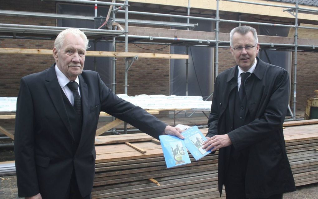 Cor ’t Lam (l.) overhandigt twee boekjes met gedichten van zijn hand aan ds. N. den Ouden, predikant van de hersteld hervormde gemeente te Leerbroek. beeld André Bijl