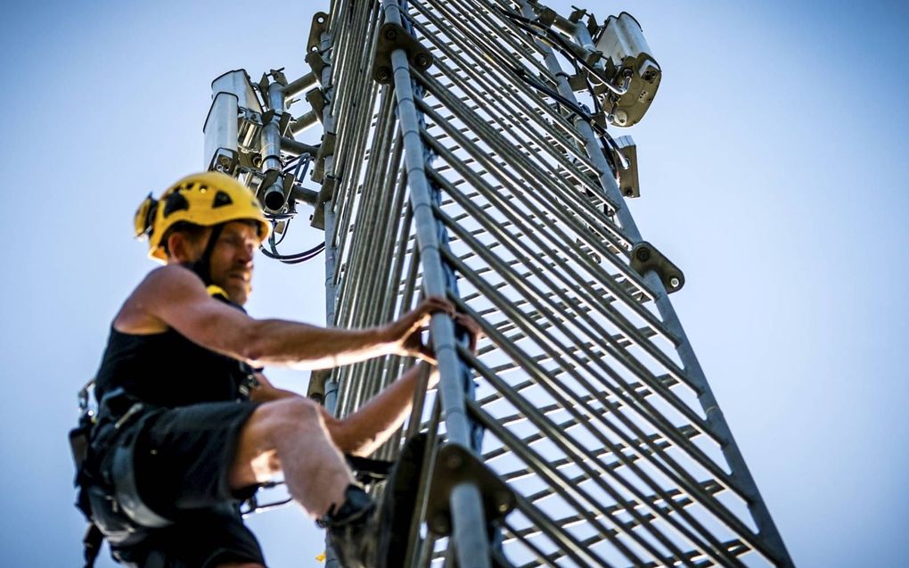 Een monteur beklimt een 5G-zendmast in ​Veldhoven. beeld ANP, Rob Engelaar