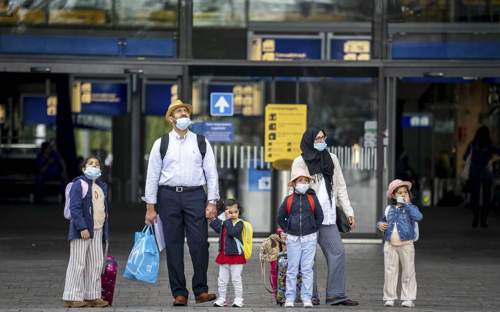 In Rotterdam en omstreken stijgt het aantal coronabesmettingen opnieuw. Op de foto: Een gezin met mondkapjes op voor het Centraal Station in de havenstad. beeld ANP, Jerry Lampen