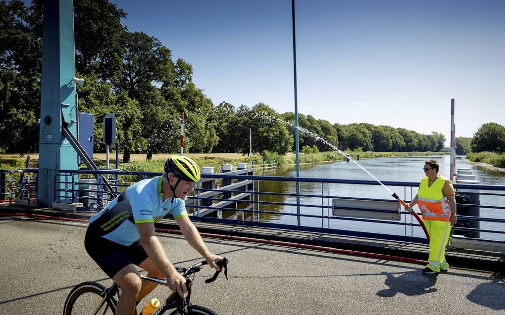 Het wegdek van de Oude IJsselbrug bij Laag-Keppel wordt besproeid vanwege de hoge temperaturen. Dat is nodig om te voorkomen dat de bruggen door de hitte vast komen te zitten. beeld ANP, Robin van Lonkhuijsen