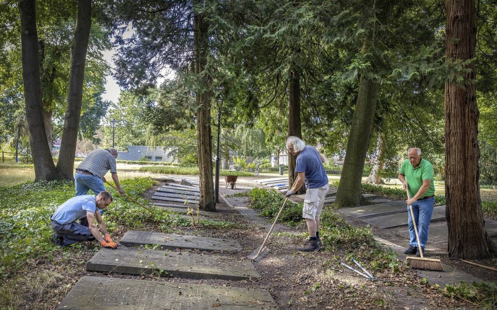 Vrijwilligers knappen de eerste algemene begraafplaats van Veenendaal op. De dodenakker was jarenlang nauwelijks onderhouden. beeld RD. Henk Visscher