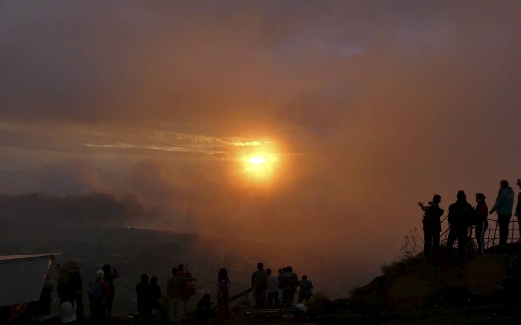 De zon verschijnt boven de bergen ten oosten van Gunung Batur. beeld Kees van Reenen