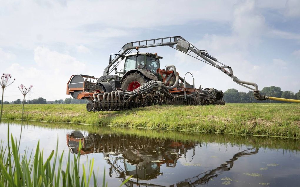 Een medewerker bemest grasland. Om de bodem te sparen wordt de mest via een zogeheten sleepslang aangevoerd uit een tussenopslag die bij de weg staat. De trekker rijdt op banden met lage spanning. beeld Niek Stam