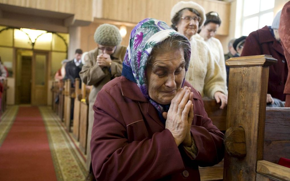 Een Russische vrouw bidt tijdens een eredienst in de Central Baptist Church in de stad Nizjni Novgorod. beeld IMB, Cat Norman