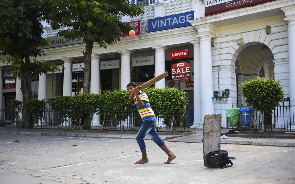 Een schoenpoetser speelde maandag cricket op een lege parkeerplaats van een marktgebied in New Delhi. De Indiase economie werd keihard getroffen door de uitbraak van het coronavirus en de omvangrijke lockdownmaatregelen tegen de pandemie die het openbare 