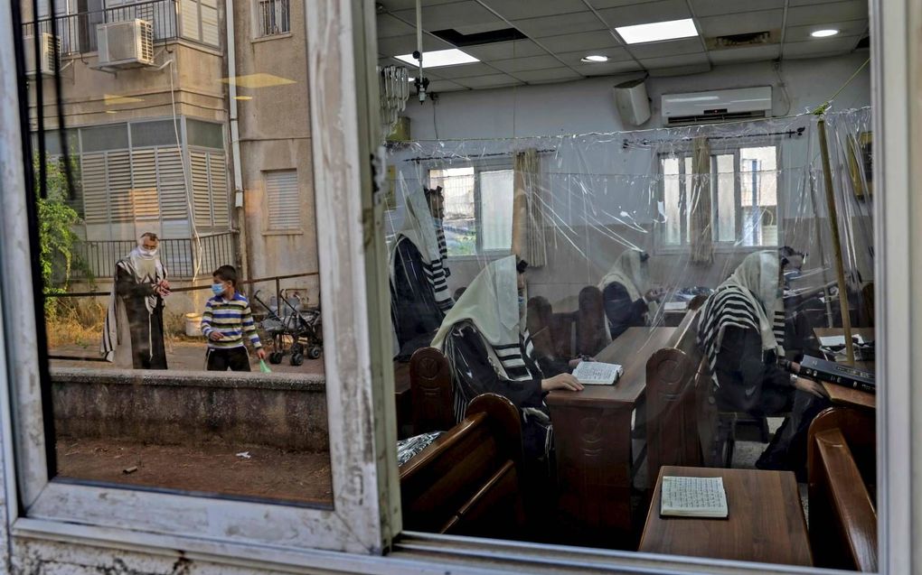 Ultraorthodoxe Joden bidden in een synagoge in Bnei Brak, in de buurt van Tel Aviv. In de stad zijn veel coronabesmettingen. beeld AFP, Menahem Kahana