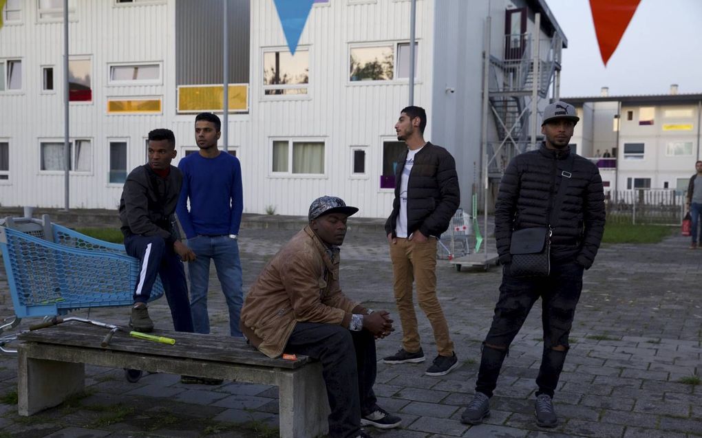 Bewoners van Startblok Riekerhaven in Amsterdam vragen zich op een kille en regenachtige avond buiten af of een gepland ”startblokfestival” door zal gaan. beeld Karijn Kakebeeke