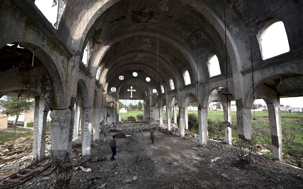 Een Syrische man bekijkt de ruïne van de Tal Nasri-kerk in de Khaburvallei, in het noordoosten van Syrië, 2019. De kerk werd verwoest door IS-strijders. beeld EPA, Murtaja Lateef