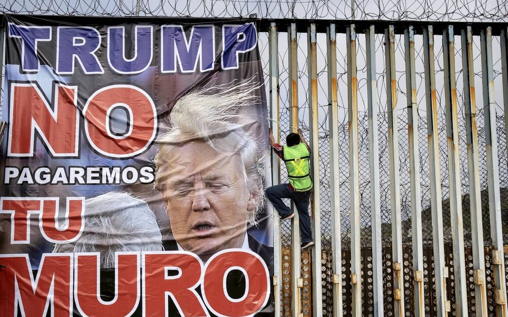 ”Trump, wij betalen niet voor jouw muur”, luidt de tekst op een spandoek dat Mexicanen begin dit jaar bevestigden aan een grenshek dat Mexico van de Verenigde Staten scheidt. beeld AFP, Guillermo Arias