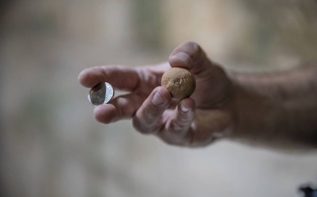 Rechts het gevonden gewicht uit de Eerste Tempelperiode. Links een muntstuk uit het hedendaagse geldverkeer ter waarde van twee sjekels. beeld Israëlische Oudheidkundige Dienst, Shai Halevi