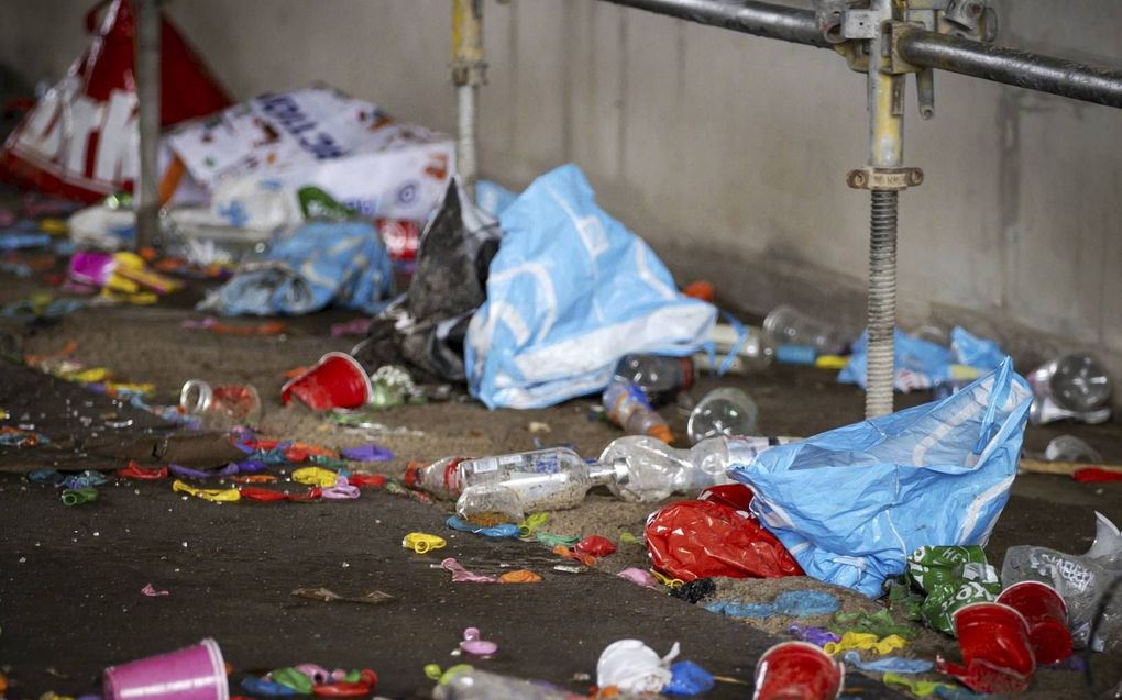 De feestgangers in Hilversum lieten een enorme bende achter, onder meer honderden lachgasballonnetjes en flessen drank. beeld ANP, Robin van Lonkhuijsen