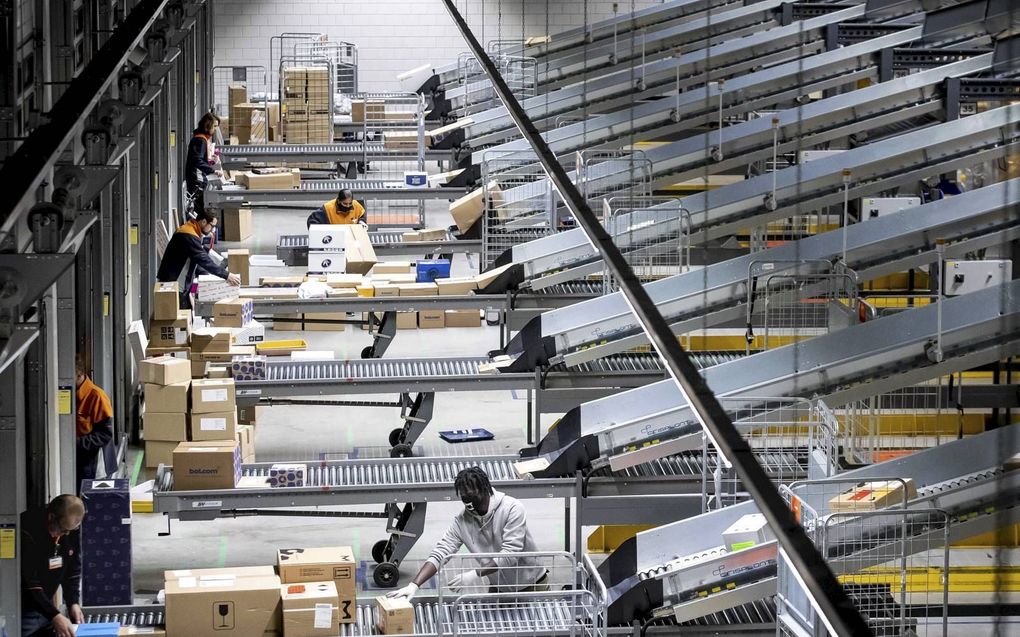 Medewerkers van PostNL sorteren pakketjes in een sorteercentrum. In aanloop naar Black Friday, Sinterklaas en Kerst wordt, in verband met corona, een van de drukste periodes ooit verwacht.  beeld ANP, Sem van der Wal