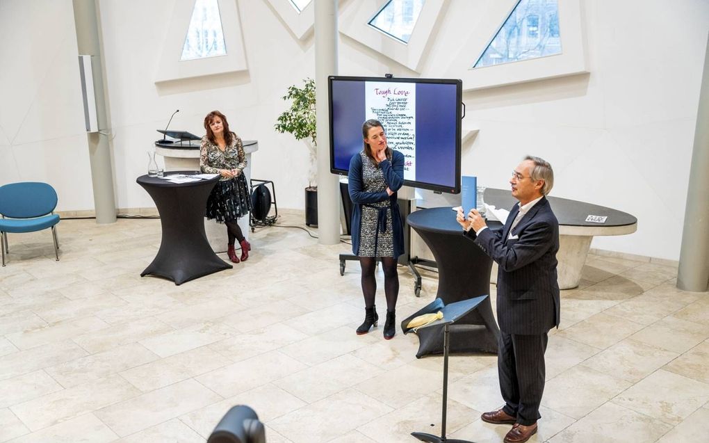 Ds. Dick Couvée (r.) nam vrijdag bij zijn afscheid van de Pauluskerk in Rotterdam een voor hem samengesteld boek in ontvangst. beeld Cees van der Wal