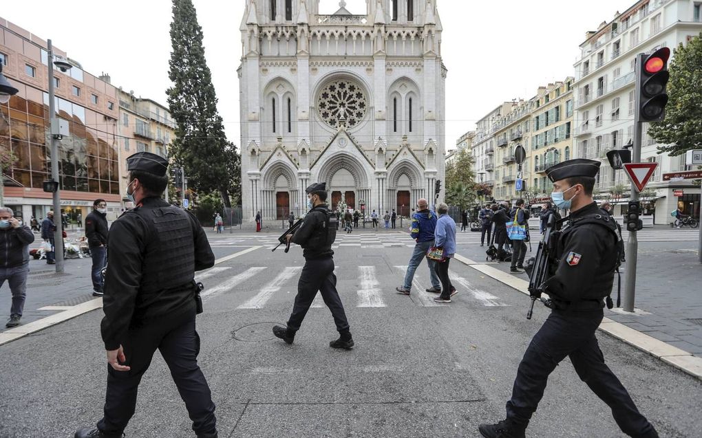 Franse agenten patrouilleren voor de basiliek van Notre-Dame in Nice, daags na de aanslag van 29 oktober. beeld AFP, Valery Hache