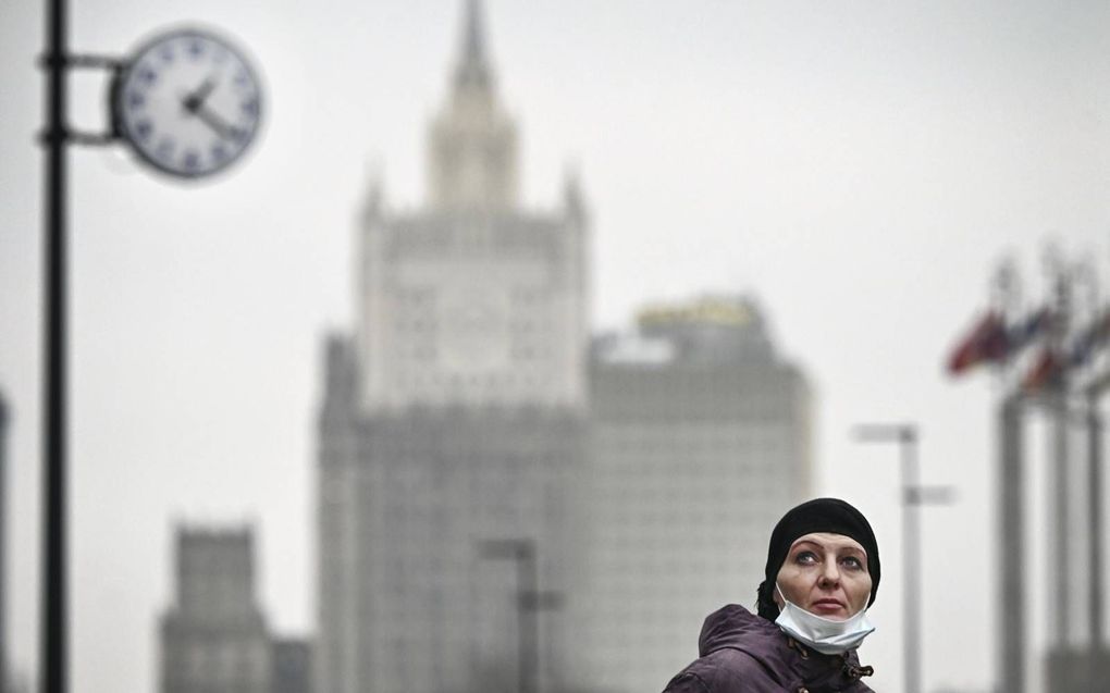 Een voetganger draagt ​​een gezichtsmasker terwijl ze door het centrum van Moskou loopt. Prijsstijgingen zijn bij minstens 61 procent van de Russische bevolking de grootste bron van zorgen. beeld AFP, Alexander Nemenov