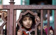 Een islamitisch jongetje in Srinagar, het Indiase deel van Kashmir, luistert naar een moslimgeestelijke. beeld EPA, Farooq Khan
