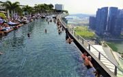 Spectaculair zwemmen in de ”infinity pool” (oneindig zwembad) op het dak van Marina Bay Sands Hotel. beeld Marius Bremmer