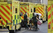 Ambulances staan te wachten bij een ziekenhuis in Londen. Vanwege het grote aantal ernstig zieke coronapatiënten in het Verenigd Koninkrijk –meer dan tijdens de eerste golf– kunnen veel ziekenhuizen de toestroom nauwelijks meer aan. beeld AFP, Daniel Leal-Olivas
