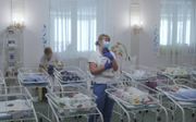 Verpleegkundigen zorgen in mei 2020 voor pasgeboren baby’s in een hotel in Kiev, Oekraïne. Zo’n vijftig draagmoederbaby’s wachten op hun buitenlandse ouders. De wensouders kunnen echter het land niet in omdat de grenzen van Oekraïne zijn gesloten vanwege de uitbraak van het coronavirus. beeld EPA, Sergey Dolzhenko