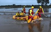 Een reddingsteam van de brandweer redt twee mannen die werden verrast door de overstroming uit een auto in de buurt van Brisbane. beeld EPA, Darren England