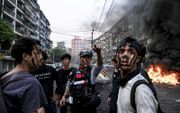 ​Grimmige beelden uit Myanmar. Jonge betogers hebben dinsdag barricades opgeworpen in de straten van Yangon.  beeld AFP