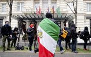 Een lid van de Iraanse oppositie betoogde dinsdag voor het Grand Hotel in Wenen, waar Iran, China en Europese partners over de nucleaire ambities van Teheran praten. beeld AFP, Joe Klamar