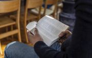Een Iraanse asielzoeker leest de Bijbel in zijn eigen taal, het Farsi. beeld RD, Henk Visscher