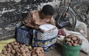 Een vrouw uit Tanzania leest op straat uit haar Bijbel. beeld RD